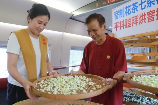 10月1日，福州市茉莉花茶窨制工藝代表性傳承人張子建與旅客在G1634次列車上制作茉莉花茶。新華社記者周義 攝