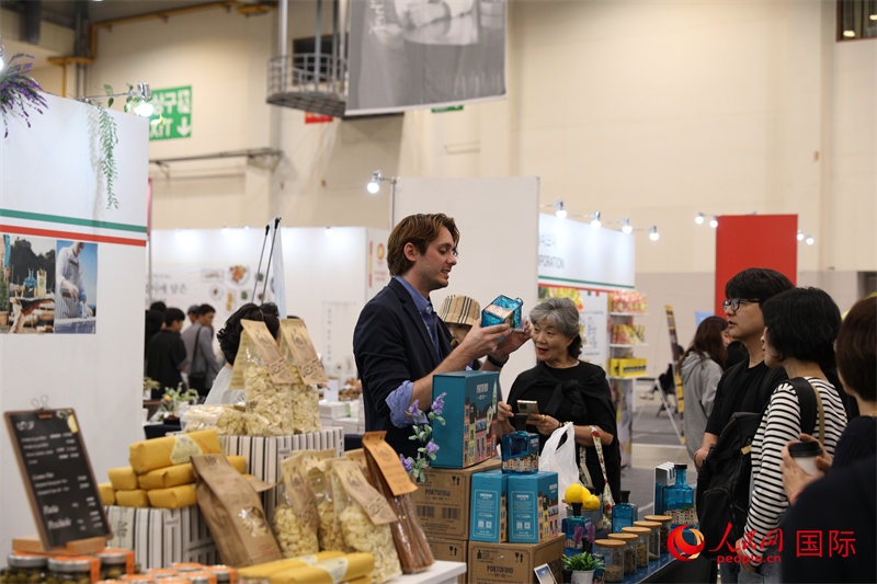 當(dāng)?shù)貢r(shí)間10月5日，在第21屆釜山國際美食博覽會(huì)上，意大利展商向參觀者們介紹的意大利食品。人民網(wǎng)記者 莽九晨攝
