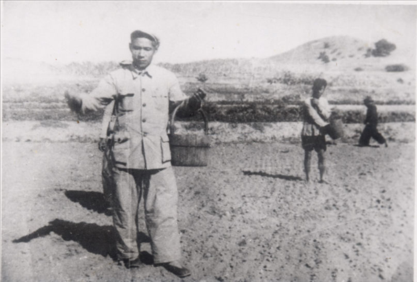 谷文昌（左）在田間與農(nóng)民一起勞動(dòng)（資料照片）。