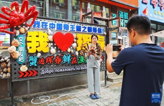 9月21日，游客在吉林省琿春市一處帝王蟹元素主題裝飾前拍照留念。新華社發(fā)