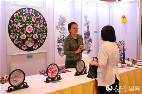 青海非遺文化傳承人向嘉賓介紹展品。人民網(wǎng)實習生姚欣可攝
