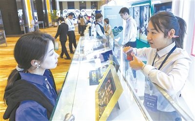 在北京麗澤商務區(qū)，工作人員（右一）介紹數字人民幣SIM卡硬錢包。新京報記者 陶冉攝