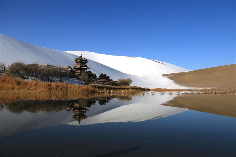 鳴沙山月牙泉景區(qū)雪景。敦煌市委宣傳部供圖，張曉亮攝
