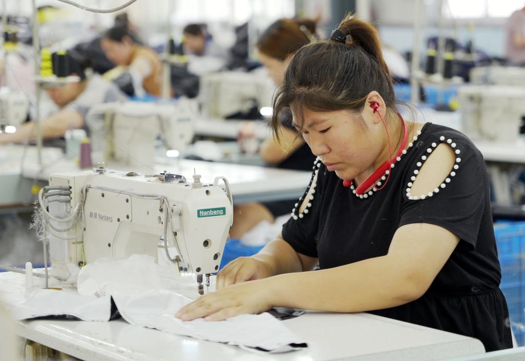 5月20日，村民在李寨村服裝加工廠內(nèi)忙碌。河南省周口市沈丘縣馮營鎮(zhèn)李寨村地處豫東平原。近年來，乘著脫貧攻堅與鄉(xiāng)村振興政策的東風(fēng)，李寨村積極探索產(chǎn)業(yè)發(fā)展模式，通過“龍頭企業(yè)+村集體經(jīng)濟(jì)+農(nóng)戶”的方式，逐漸發(fā)展形成肉牛養(yǎng)殖、設(shè)施農(nóng)業(yè)、服裝加工、康養(yǎng)民宿等產(chǎn)業(yè)，以產(chǎn)業(yè)振興助力鄉(xiāng)村振興。新華社記者 李嘉南 攝