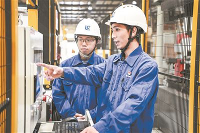 在廣西柳工機(jī)械股份有限公司生產(chǎn)車間內(nèi)，一名高級(jí)技師（右）給徒弟講解數(shù)控設(shè)備操作細(xì)節(jié)。新華社記者 曹祎銘攝