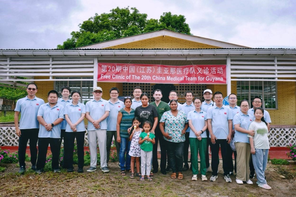 第20期中國（江蘇）援圭亞那醫(yī)療隊在圭偏遠的林登高速社區(qū)開展義診后，與部分當?shù)鼐用窈嫌啊?中國援圭醫(yī)療隊供圖