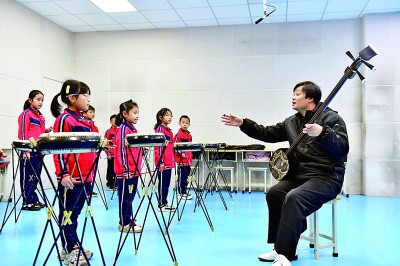 圖為12月30日，在惠民縣胡集鎮(zhèn)第一小學(xué)，老師指導(dǎo)學(xué)生學(xué)習(xí)西河大鼓。新華社記者 郭緒雷攝