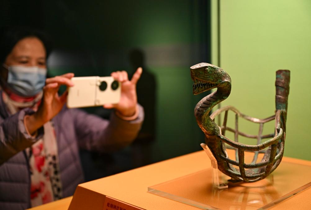 1月14日，觀眾在上海博物館蛇年迎春展拍攝展品蛇綱網(wǎng)狀銅器。新華社發(fā)（陳浩明攝）