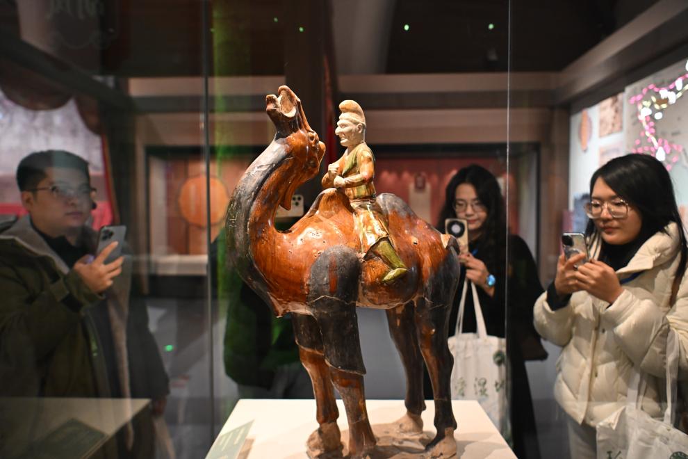 1月15日，觀眾在拍攝“長(zhǎng)安三萬(wàn)里——陜西唐代文物精華展”展出的三彩胡人騎駝俑。（新華社記者 孫凡越 攝）