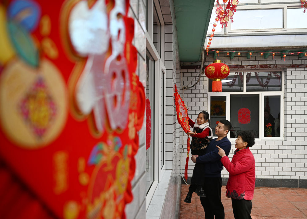 天津市西青區(qū)辛口鎮(zhèn)第六埠村村民在院子里掛“福”字（2024年2月1日攝）。新華社記者 趙子碩 攝