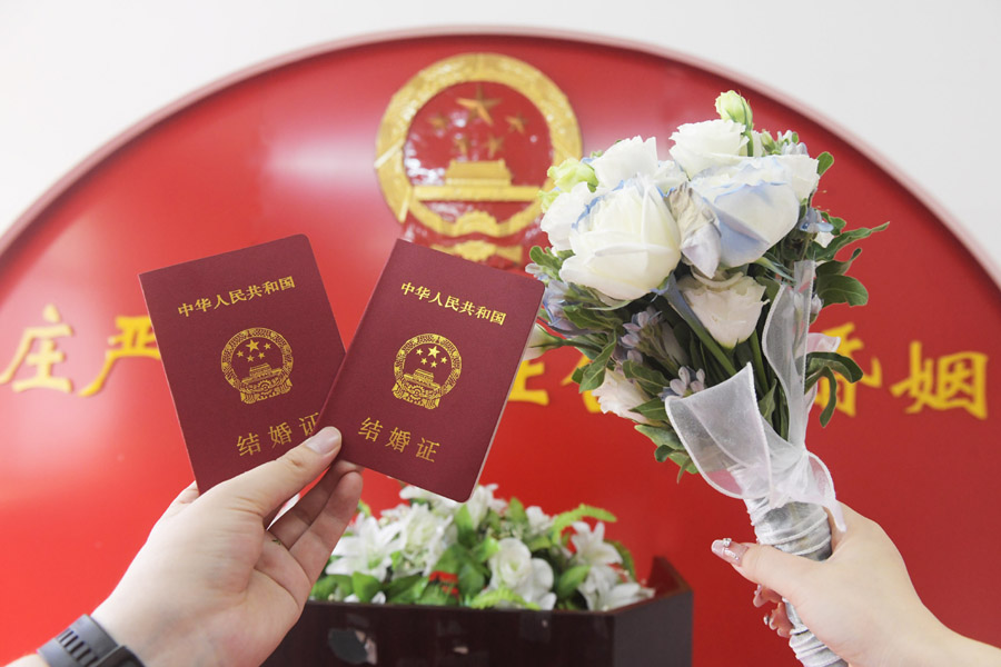 2024年8月10日，一對新人在河北石家莊新樂市民政局婚姻登記處領(lǐng)取結(jié)婚證后拍照留念。新華社發(fā)（賈敏杰攝）