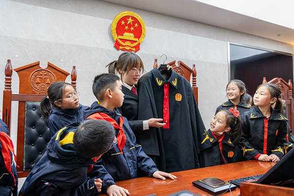 圖②：干警向同學(xué)們介紹法袍。