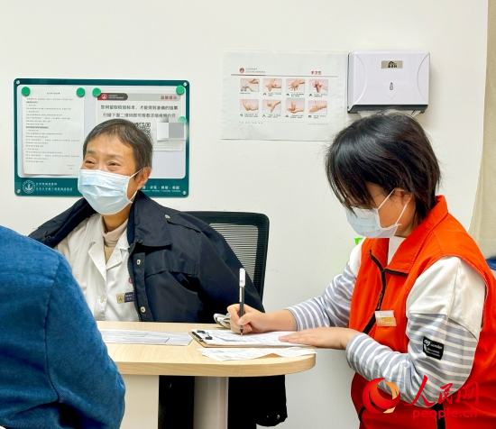秦苑（中）接診患者。人民網(wǎng)記者 金慧慧攝