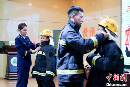 圖為學(xué)生們現(xiàn)場穿戴消防頭盔和戰(zhàn)斗服。中新社記者 趙宇航 攝