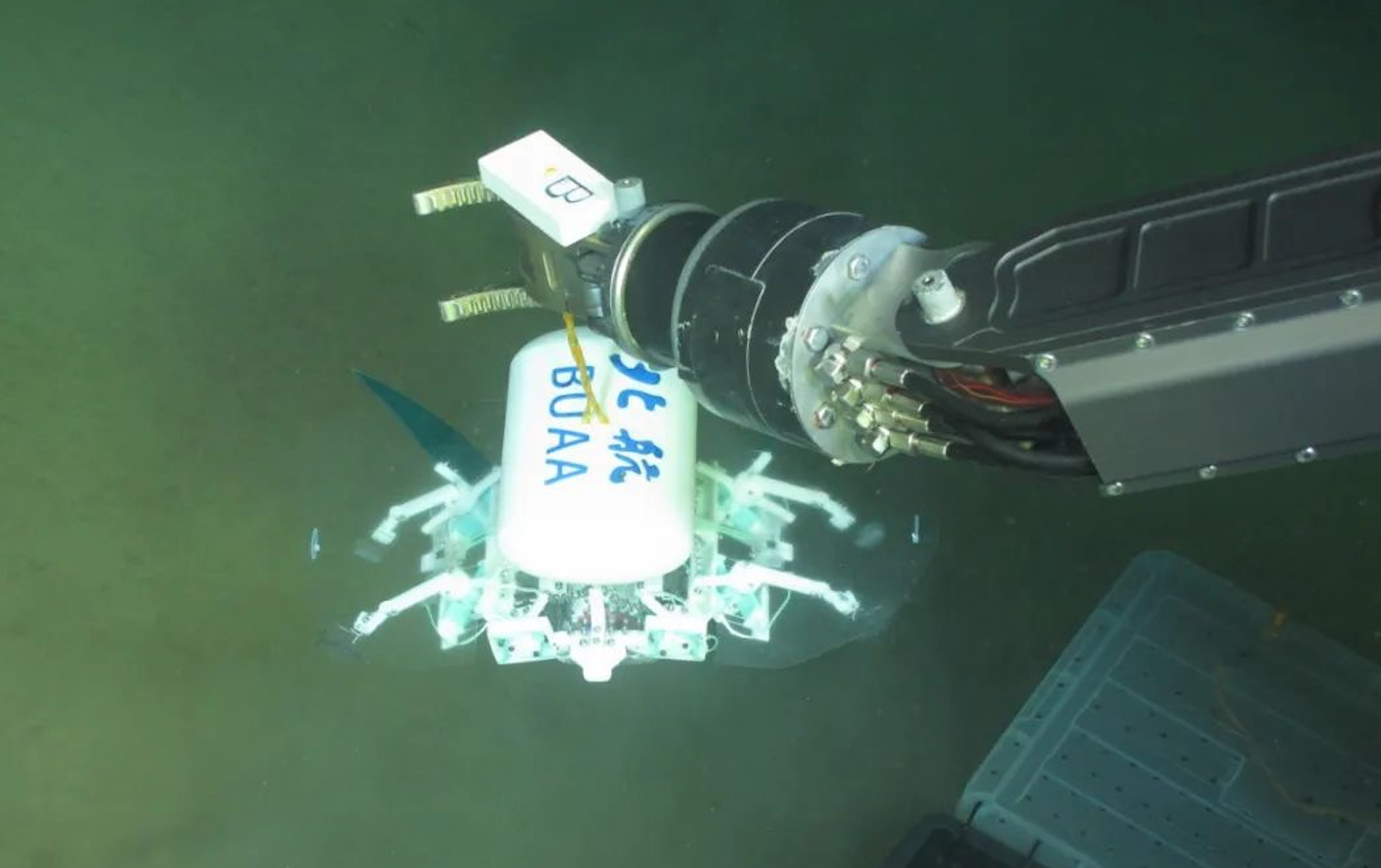 科研人員利用機械臂將北航深海小型機器人投于馬里亞納海溝。校方供圖