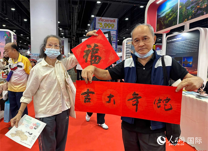 2025蛇年春節(jié)，泰國(guó)市民展示他們領(lǐng)到的華人手寫(xiě)春聯(lián)。人民網(wǎng)記者 簡(jiǎn)承淵攝