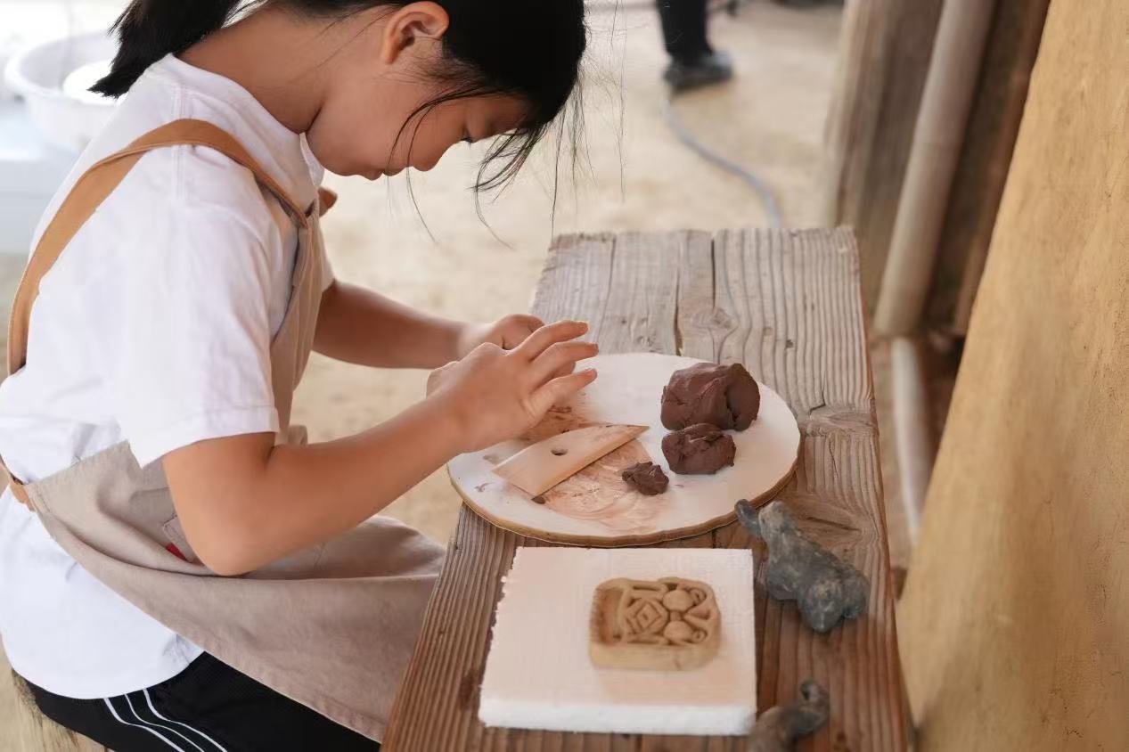 游客制作良渚特色陶藝品。良渚博物院供圖