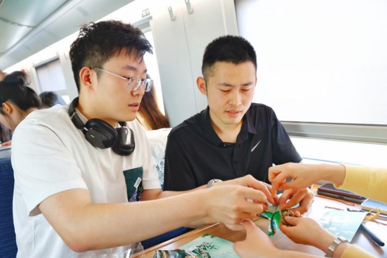 G232次旅客親手制作端午荷包和五彩繩。王磊攝