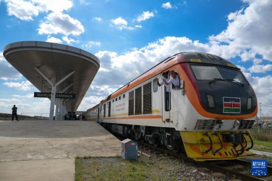 5月31日，在蒙內(nèi)鐵路內(nèi)羅畢站，機車駕駛員蔣立平（右）和博爾在即將開往蒙巴薩的E2次列車上揮手致意。新華社記者 楊光 攝