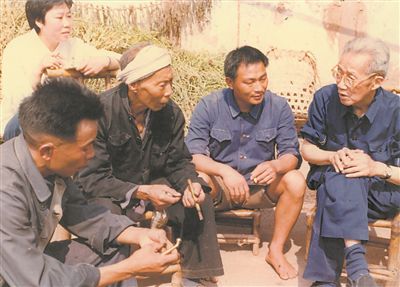 侯光炯（右一）和農民在一起親切交流。 西南大學檔案館供圖